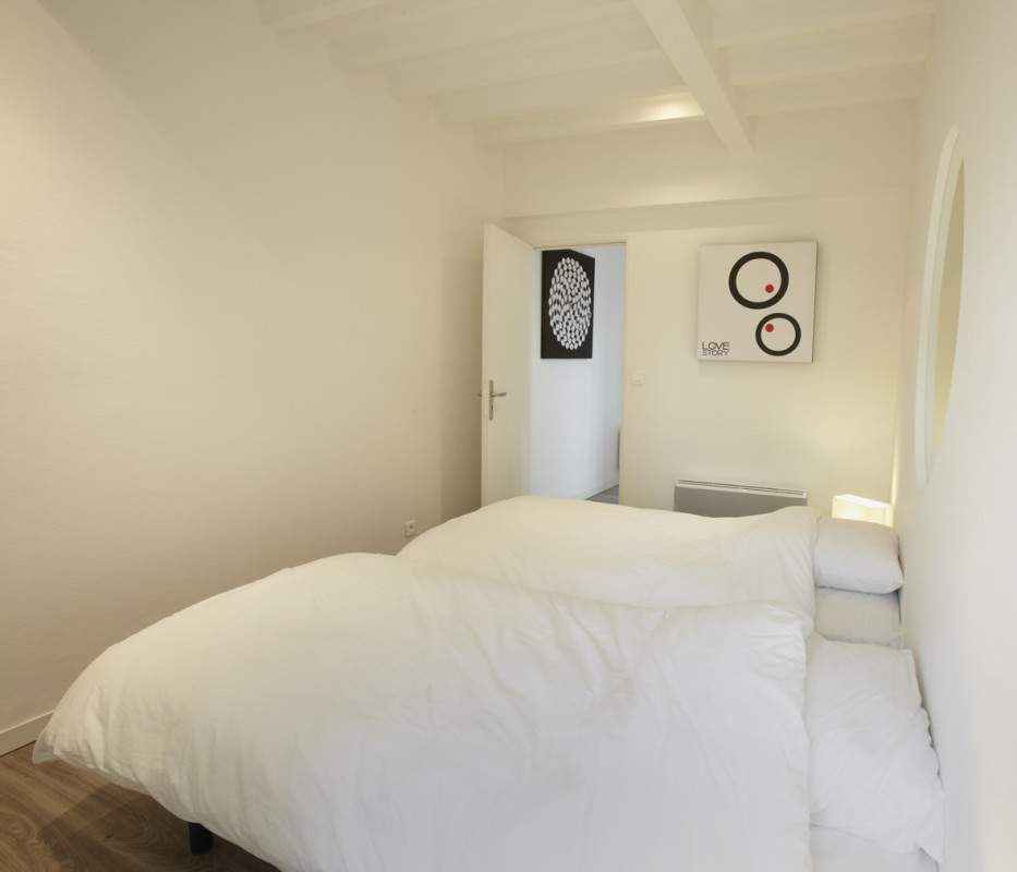 Chambre du Gîte Gabrielle avec lits jumeaux modulables et décoration minimaliste.