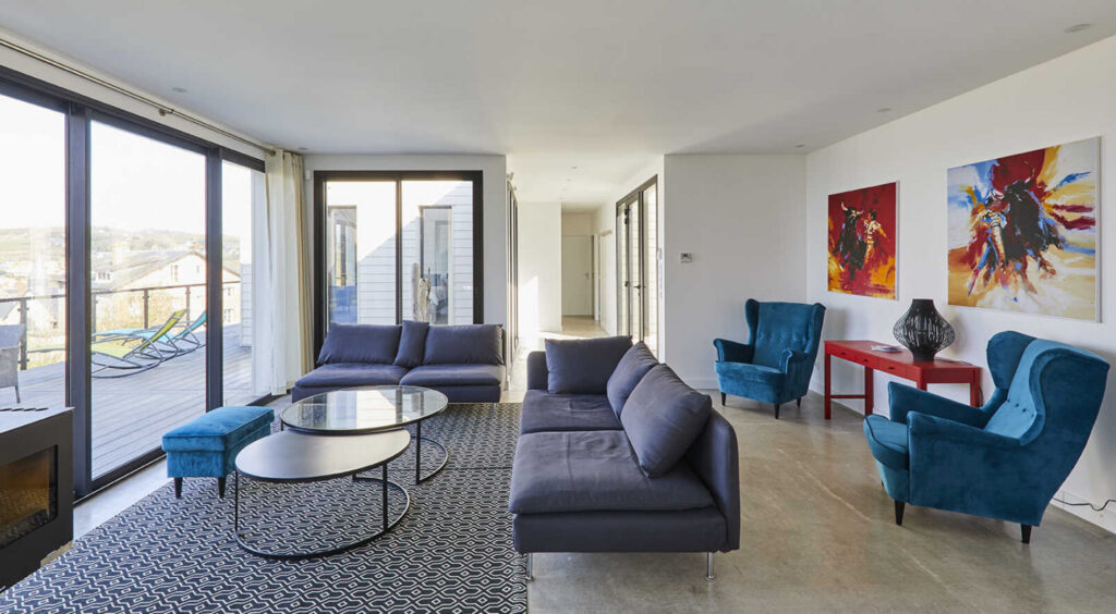 Salon élégant de la Villa Gabrielle, gîte à Pourville-sur-Mer avec fauteuils design et vue dégagée sur la côte normande.
