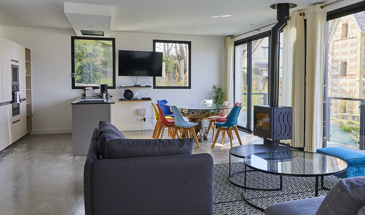 Séjour lumineux avec cuisine équipée, coin repas et poêle à bois dans la Villa Gabrielle, location de vacances à Pourville-sur-Mer près de Dieppe.